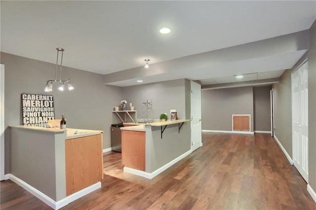216 Beagle Dr, Moon/Crescent Twp, PA 15108 - kitchen with a peninsula, wood finished floors, a kitchen breakfast bar, decorative light fixtures, and light countertops