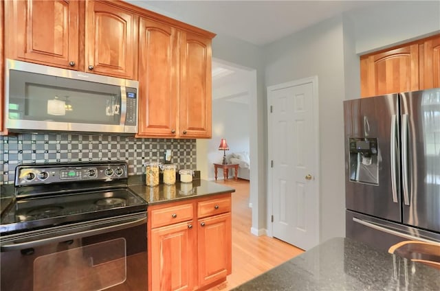 216 Beagle Dr, Moon/Crescent Twp, PA 15108 - kitchen with appliances with stainless steel finishes, dark stone counters, backsplash, and light wood finished floors