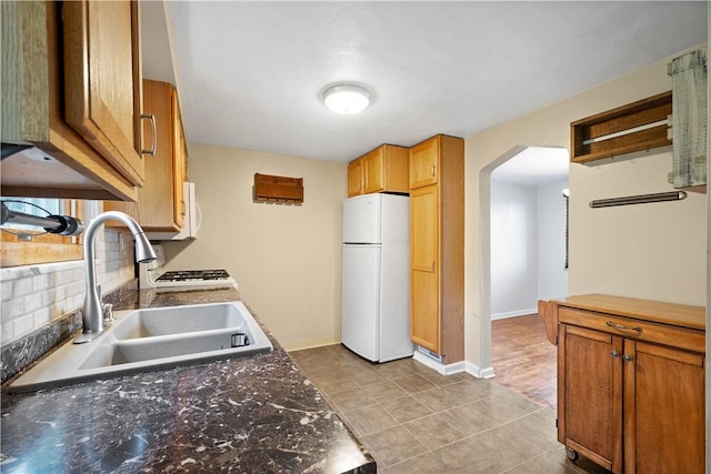 108 Bellanca Ave, Brentwood, PA 15227 - kitchen with freestanding refrigerator, arched walkways, dark countertops, light tile patterned flooring, and backsplash