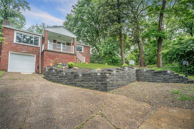 1809 Rosedale St, Verona, PA 15147 - view of side of property featuring concrete driveway, stairs, an attached garage, brick siding, and covered porch