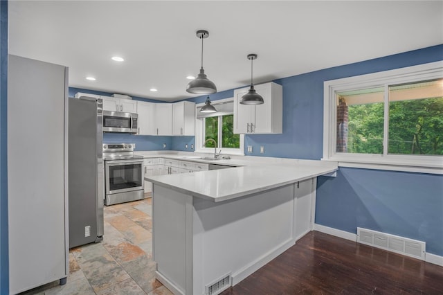 1809 Rosedale St, Verona, PA 15147 - kitchen with appliances with stainless steel finishes, a peninsula, light countertops, white cabinets, and decorative light fixtures