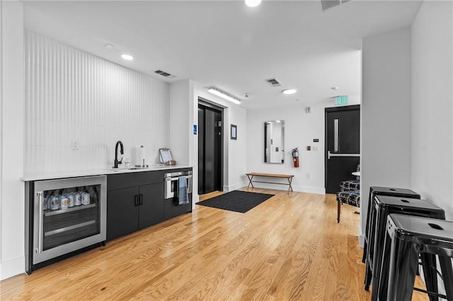 3725 Butler St Unit 306, Lawrenceville, PA 15201 - indoor wet bar with beverage cooler, light wood-style flooring, recessed lighting, and fridge