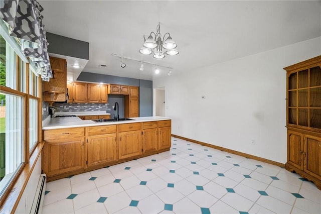 156 Riemer Rd, Buffalo Twp, PA 16055 - kitchen with a peninsula, tasteful backsplash, light countertops, brown cabinets, and a chandelier