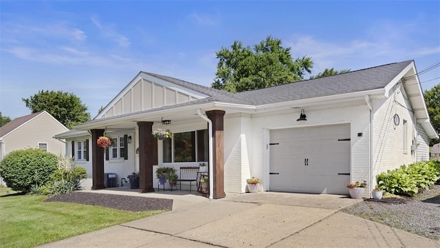 8609 Peters Rd, Cranberry Twp, PA 16066 - view of front facade featuring a porch, a garage, concrete driveway, board and batten siding, and brick siding