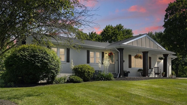 8609 Peters Rd, Cranberry Twp, PA 16066 - view of front of house with a lawn, a porch, stucco siding, and board and batten siding