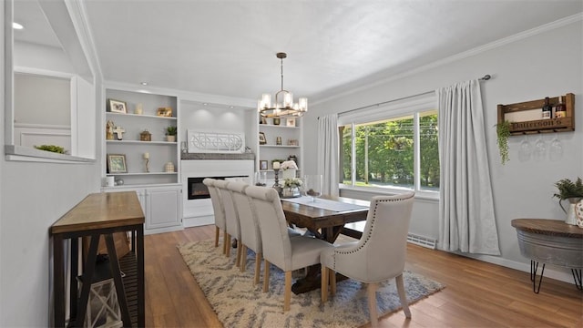 8609 Peters Rd, Cranberry Twp, PA 16066 - dining room with ornamental molding, light wood finished floors, a chandelier, and a glass covered fireplace
