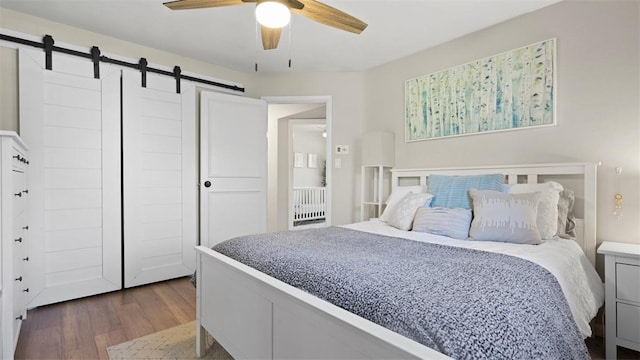 8609 Peters Rd, Cranberry Twp, PA 16066 - bedroom featuring a barn door, wood finished floors, and ceiling fan