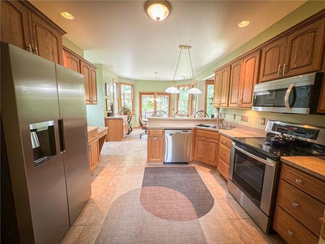 121 Covington Dr, Center Twp, PA 16001 - kitchen featuring stainless steel appliances, a peninsula, brown cabinets, hanging light fixtures, and recessed lighting