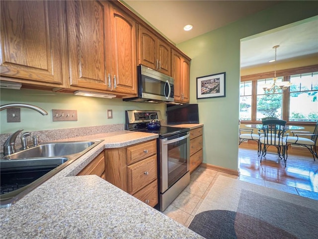 121 Covington Dr, Center Twp, PA 16001 - kitchen featuring stainless steel appliances, light tile patterned floors, brown cabinetry, light countertops, and recessed lighting