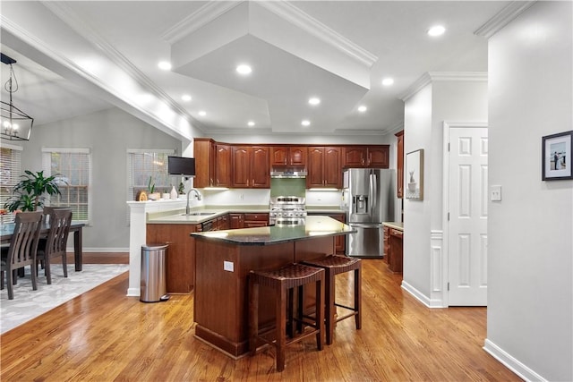 3001 Willowbrook Dr, South Fayette, PA 15017 - kitchen with appliances with stainless steel finishes, light wood finished floors, a center island, a kitchen bar, and under cabinet range hood