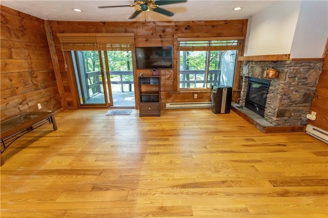 13 Lakeview Dr, Hidden Valley, PA 15502 - unfurnished living room with baseboard heating, plenty of natural light, light wood finished floors, a ceiling fan, and wood walls