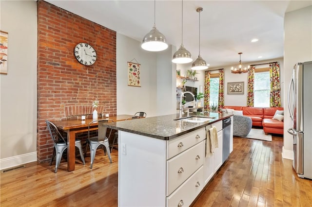 160 45th St, Lawrenceville, PA 15201 - kitchen with stainless steel appliances, light wood-type flooring, white cabinetry, dark stone countertops, and recessed lighting