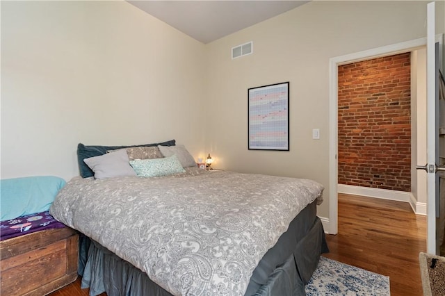 160 45th St, Lawrenceville, PA 15201 - bedroom with dark wood finished floors and brick wall