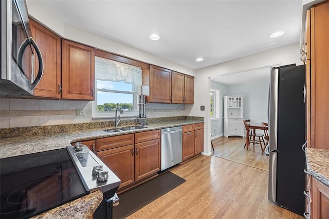 4715 Meadowgreen Dr, Whitehall, PA 15236 - kitchen featuring appliances with stainless steel finishes, light wood-style floors, decorative backsplash, brown cabinetry, and recessed lighting