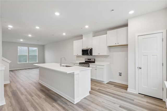 116 River Ridge Drive, Moon/Crescent Twp, PA 15108 - kitchen with stainless steel appliances, white cabinets, a center island with sink, light wood finished floors, and recessed lighting