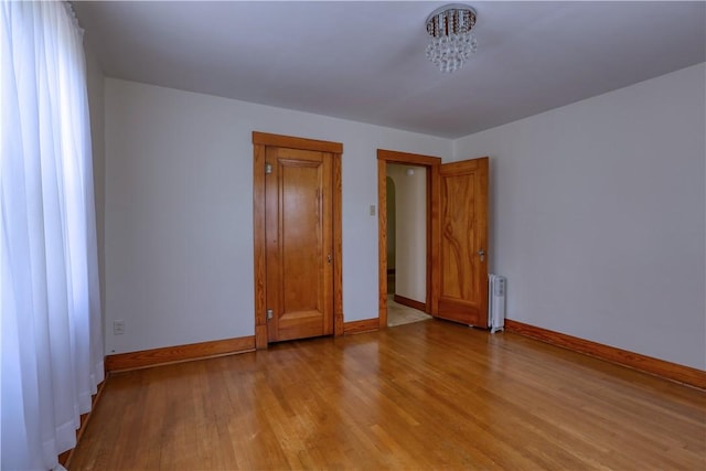 267 Blackhawk Rd, Chippewa Twp, PA 15010 - empty room with radiator, wood finished floors, and a chandelier
