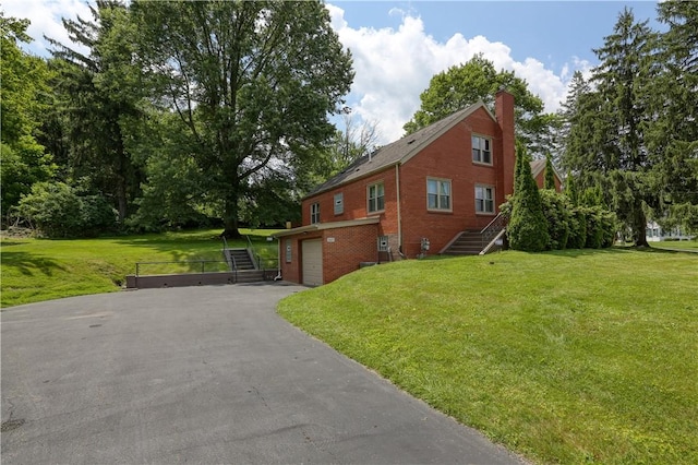 267 Blackhawk Rd, Chippewa Twp, PA 15010 - view of property exterior featuring stairway, asphalt driveway, brick siding, a garage, and a lawn