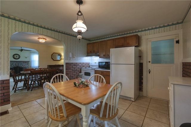 267 Blackhawk Rd, Chippewa Twp, PA 15010 - dining space featuring wallpapered walls, light tile patterned floors, arched walkways, a fireplace, and ceiling fan