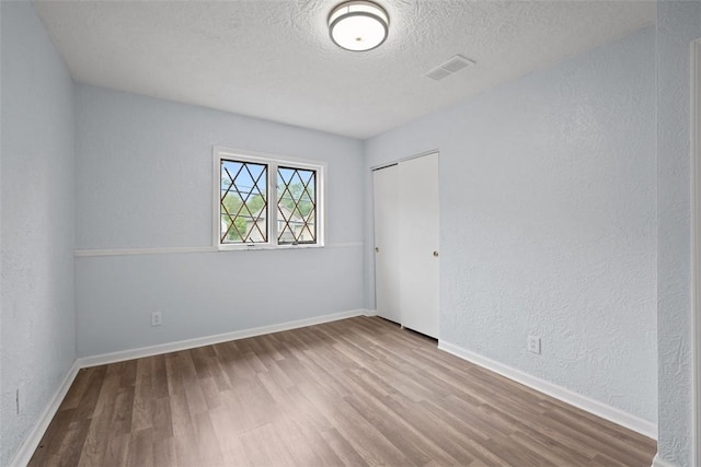 146 Mill St, Penn Hills, PA 15147 - unfurnished room featuring wood finished floors, a textured ceiling, and a textured wall