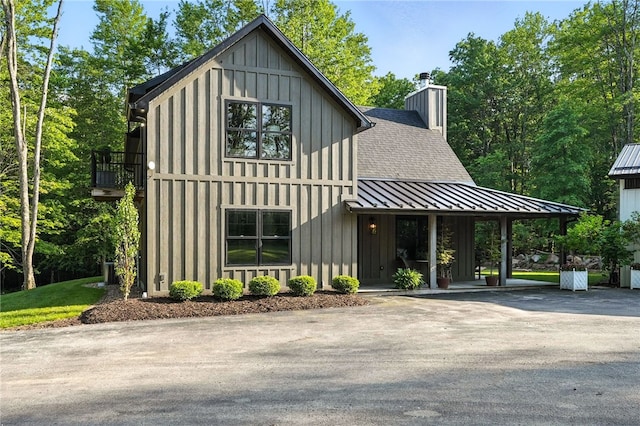 50 Hawes Rd, Wharton Twp, PA 15437 - view of front facade featuring a standing seam roof, a chimney, a metal roof, board and batten siding, and a shingled roof