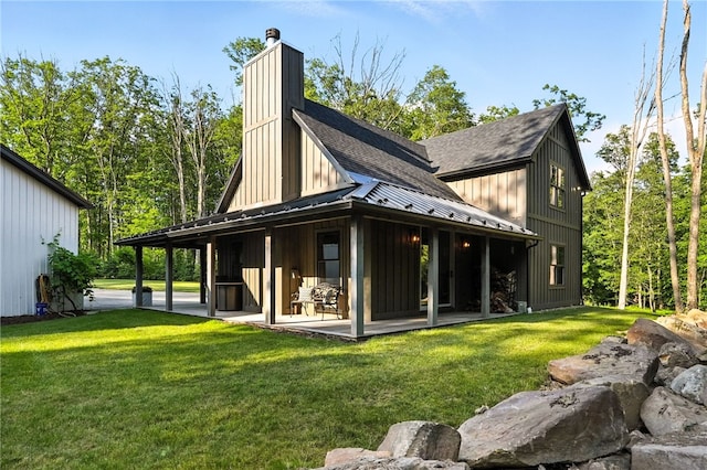 50 Hawes Rd, Wharton Twp, PA 15437 - back of property with a standing seam roof, a chimney, a metal roof, a shingled roof, and a yard