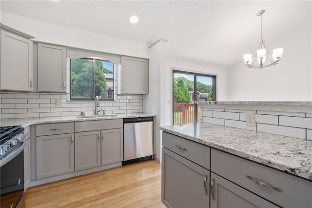 404 Beulah St, Shaler, PA 15209 - kitchen featuring appliances with stainless steel finishes, gray cabinetry, tasteful backsplash, a chandelier, and light wood-style floors