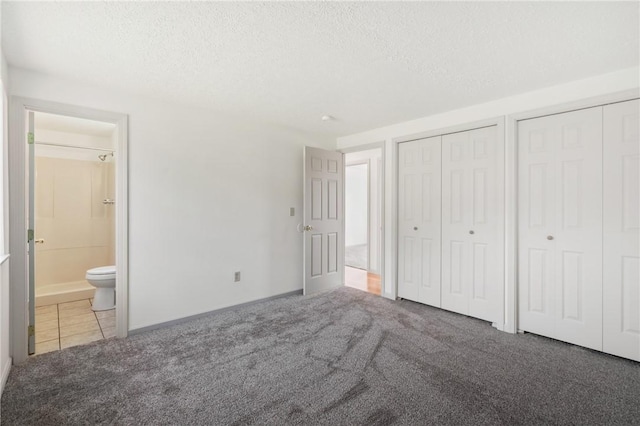 404 Beulah St, Shaler, PA 15209 - unfurnished bedroom with multiple closets, carpet flooring, a textured ceiling, ensuite bathroom, and tile patterned floors