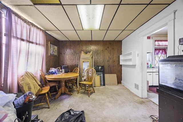 11839 Crockett St, North Huntingdon, PA 15647 - dining space featuring a drop ceiling, wood walls, and unfinished concrete floors