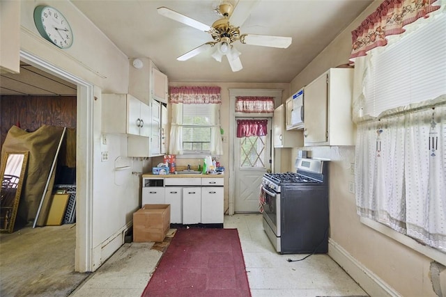 11839 Crockett St, North Huntingdon, PA 15647 - kitchen with stainless steel gas range, white cabinets, white microwave, ceiling fan, and light countertops