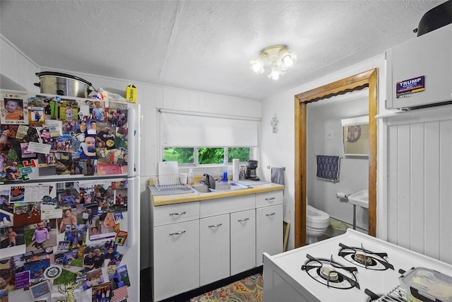 11839 Crockett St, North Huntingdon, PA 15647 - kitchen with freestanding refrigerator, a textured ceiling, gas range oven, and light countertops