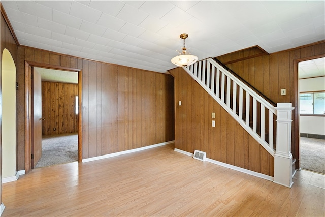 41 Taylor Ave, East Bethlehem, PA 15322 - unfurnished living room with wood walls, wood finished floors, stairs, and arched walkways