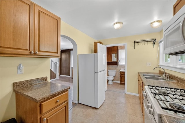 41 Taylor Ave, East Bethlehem, PA 15322 - kitchen with white appliances, arched walkways, dark countertops, and light tile patterned floors