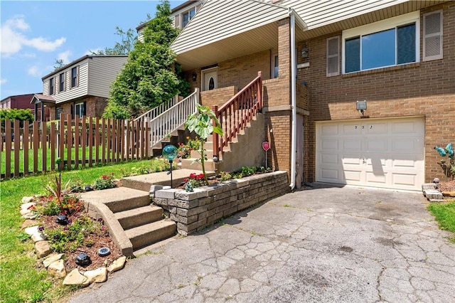 553 Indus St, Greenfield, PA 15207 - doorway to property featuring an attached garage, brick siding, and driveway