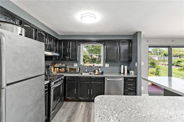 553 Indus St, Greenfield, PA 15207 - kitchen featuring stainless steel appliances, under cabinet range hood, light wood finished floors, light countertops, and dark cabinetry