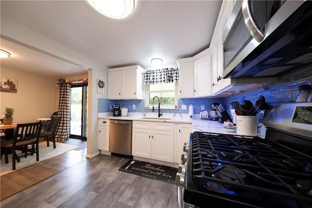 325 Clements Rd, Plum Boro, PA 15239 - kitchen with appliances with stainless steel finishes, light countertops, backsplash, white cabinetry, and dark wood-style flooring