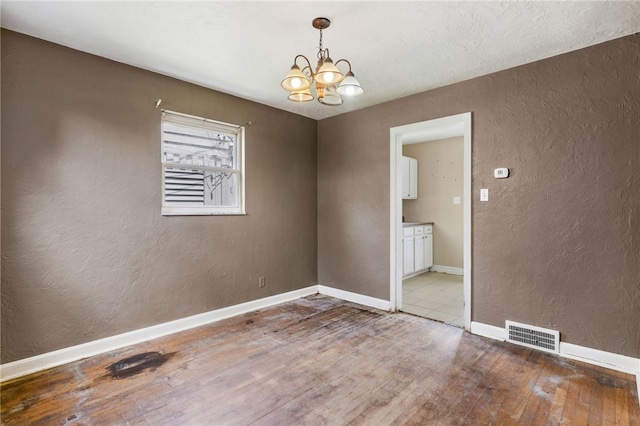 1000 Prospect Rd, Whitehall, PA 15227 - spare room with a textured wall, a chandelier, and hardwood / wood-style flooring