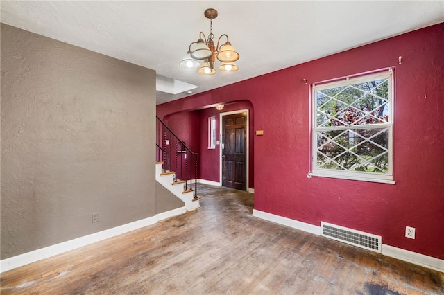 1000 Prospect Rd, Whitehall, PA 15227 - empty room with wood finished floors, a textured wall, arched walkways, a chandelier, and stairway