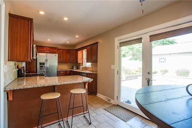101 Lynne Dr, Big Beaver, PA 15010 - kitchen with appliances with stainless steel finishes, a peninsula, tasteful backsplash, light stone countertops, and recessed lighting