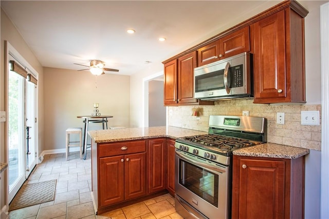 101 Lynne Dr, Big Beaver, PA 15010 - kitchen featuring stainless steel appliances, backsplash, a peninsula, light stone countertops, and a ceiling fan