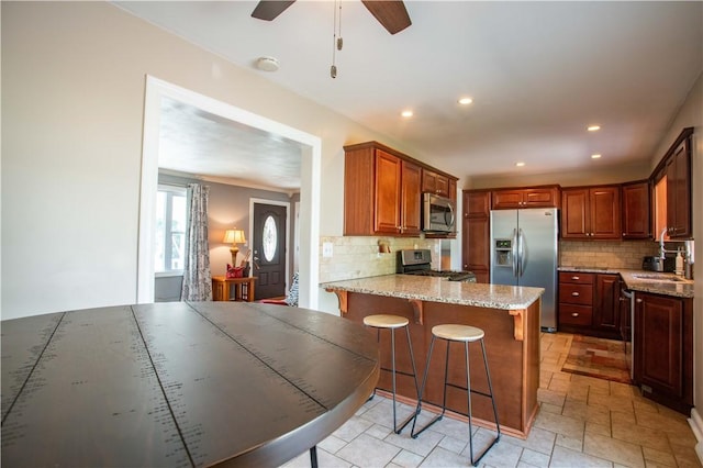 101 Lynne Dr, Big Beaver, PA 15010 - kitchen with stainless steel appliances, backsplash, a peninsula, light stone countertops, and recessed lighting