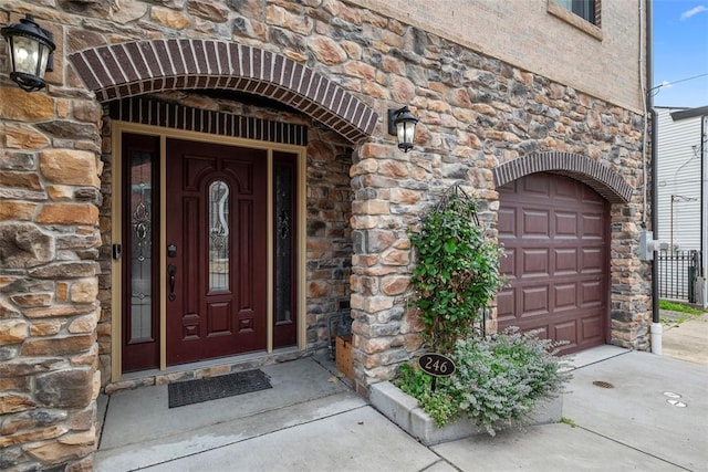 246 42nd St, Lawrenceville, PA 15201 - property entrance featuring stone siding, a garage, and driveway