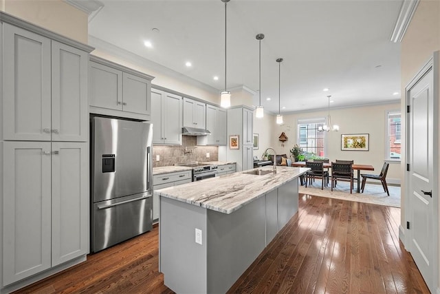 246 42nd St, Lawrenceville, PA 15201 - kitchen with appliances with stainless steel finishes, a kitchen island with sink, crown molding, decorative backsplash, and dark wood-style floors