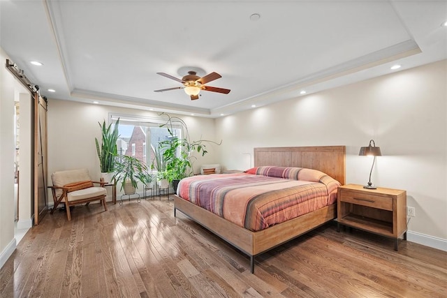 246 42nd St, Lawrenceville, PA 15201 - bedroom featuring a raised ceiling, a barn door, wood finished floors, recessed lighting, and ceiling fan