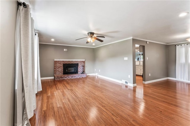 unfurnished living room with ceiling fan, light wood-type flooring, a fireplace, recessed lighting, and ornamental molding