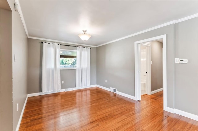 empty room featuring ornamental molding and light wood-type flooring