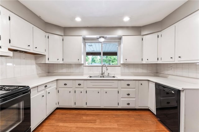 kitchen featuring black appliances, light wood-style flooring, white cabinets, decorative backsplash, and light countertops