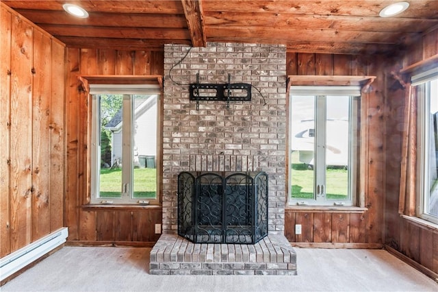 living area with wood ceiling, a baseboard heating unit, wooden walls, plenty of natural light, and a fireplace