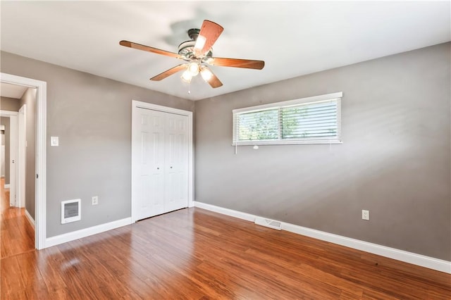 unfurnished bedroom with a closet, wood finished floors, and ceiling fan