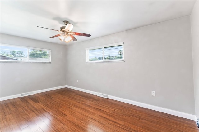 unfurnished room featuring plenty of natural light, ceiling fan, and wood finished floors