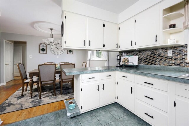 16 Grace Rd, Scottdale, PA 15683 - kitchen with white cabinetry, decorative backsplash, open shelves, dark tile patterned floors, and a peninsula